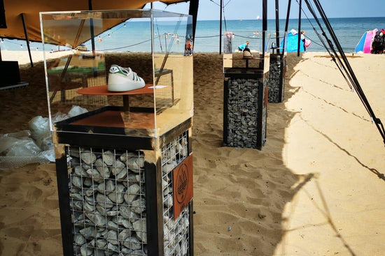 Tent with a glass display case on a sandy beach with ocean view