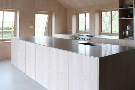 Modern kitchen with wooden walls and a large island.